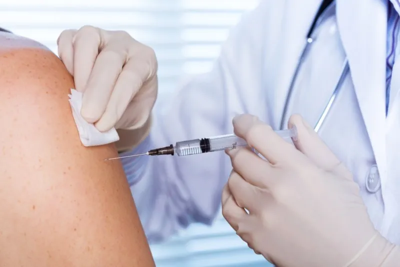 close up of a doctor making a vaccination in the shoulder of patient