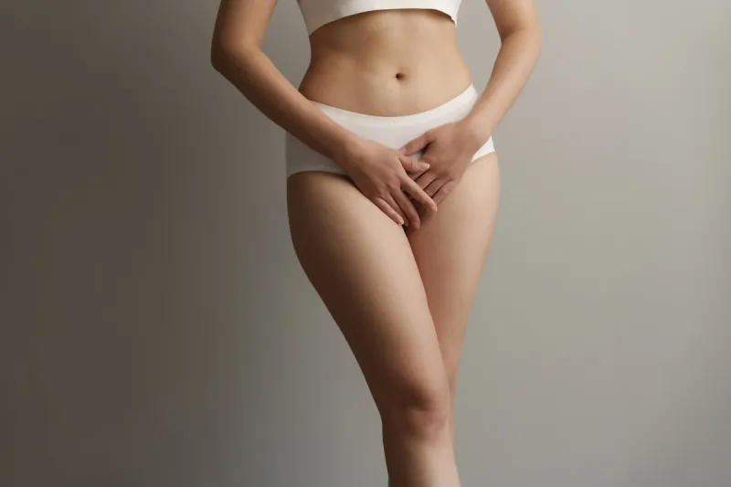 close up asian woman cropped shot with white panties on grey background, vagina healthy concept