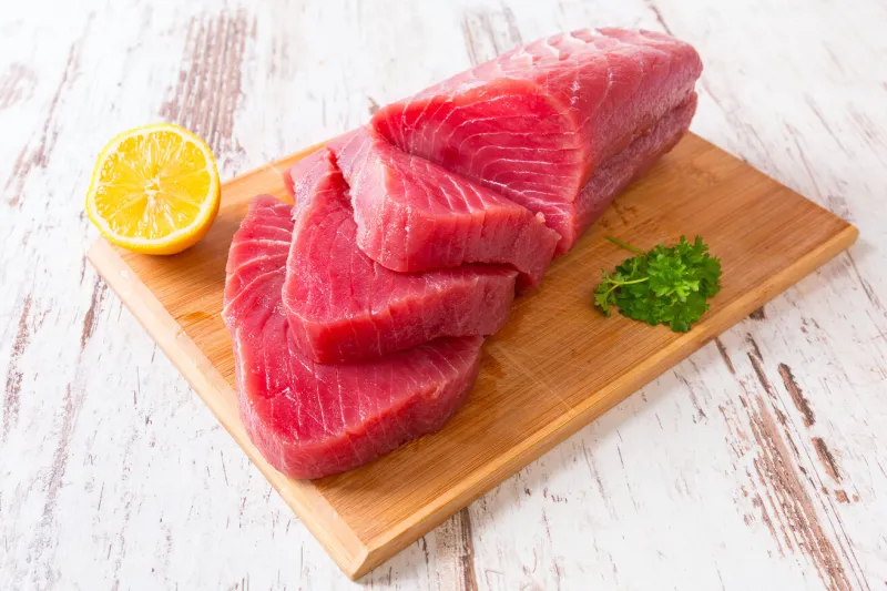 raw tuna steak on wooden cutboard