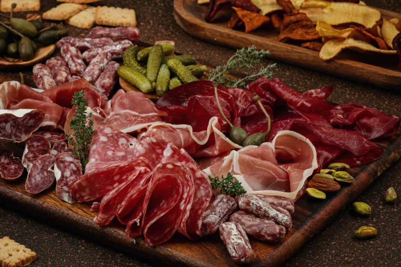 appetizers table with differents antipasti, charcuterie, snacks and wine sausage, ham, tapas, olives, cheese and crackers for buffet party top view, flat lay