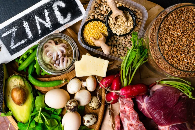 foods high in zinc as octopus, beef, buckwheat, yellow cheese, spinach, avokado,pea, mushrooms, bean, radishes, eggs top view