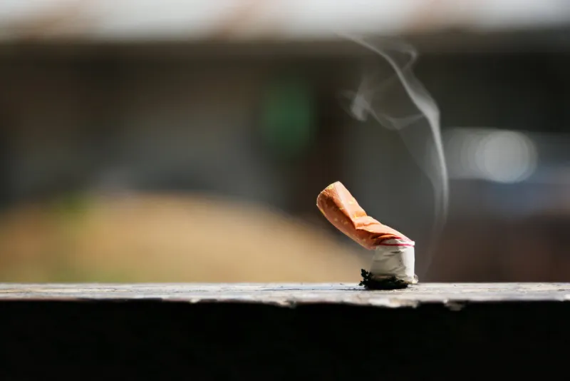 brown color filter bottom cigarette on wooden floor