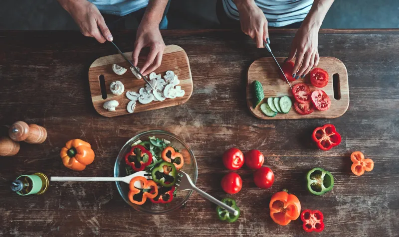 cropped image of romantic couple is cooking on kitchen handsome man and attractive young woman are having fun together while making salad healthy lifestyle concept