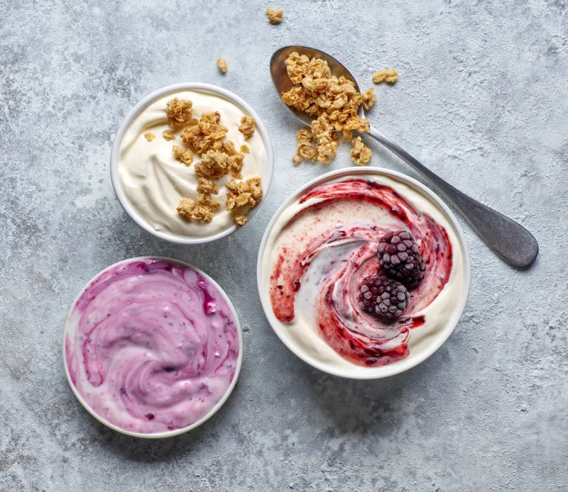 bowls of various greek yogurt on kitchen table, top view