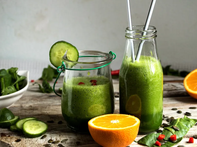 gläser mit spinat- und gurken-smoothie mit orangen verfeinert