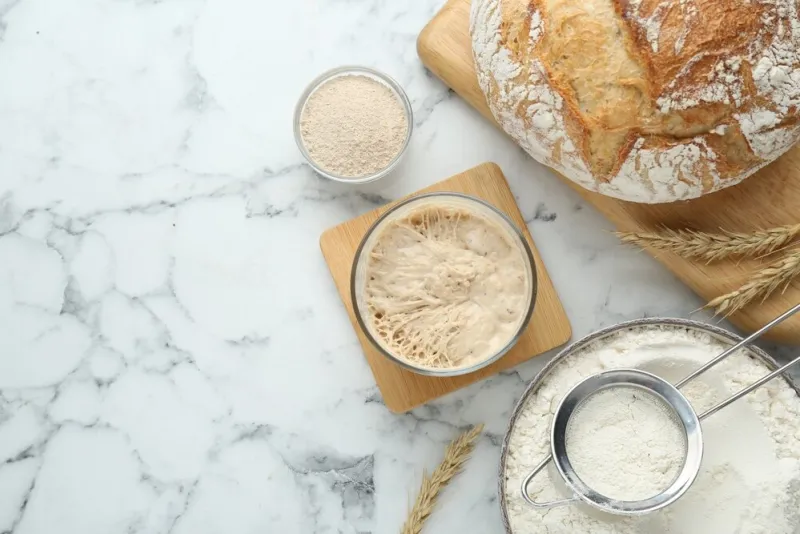 flat lay composition with sourdough on white marble table space for text