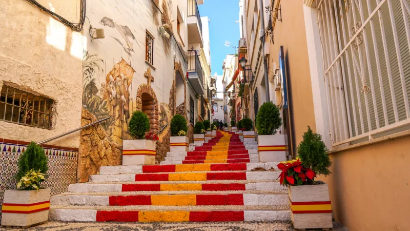 stairs of a street of calpe in alicante painted with the colors of the national flag