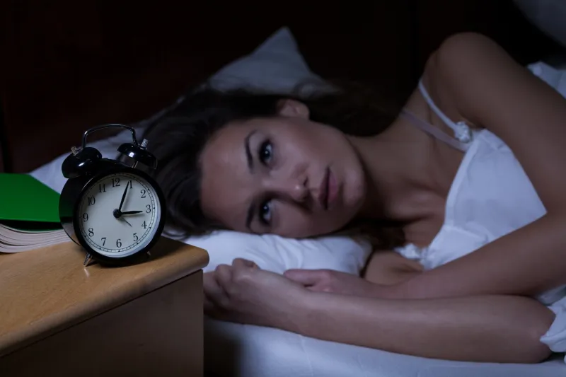 woman with insomnia lying in bed with open eyes