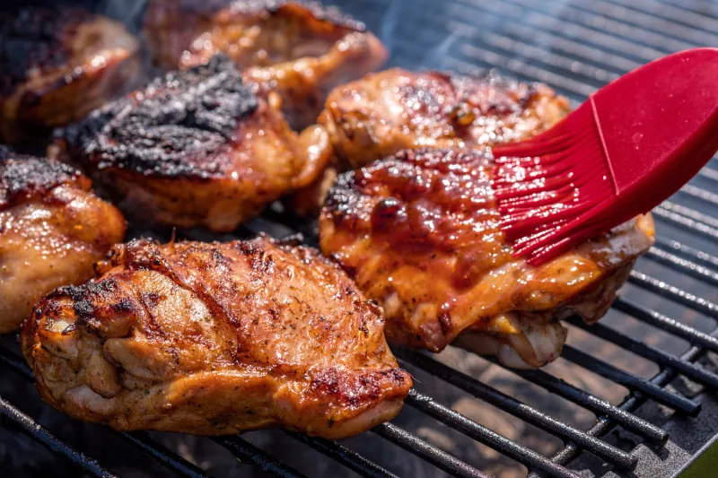 grilled chicken thigh on the flaming grill