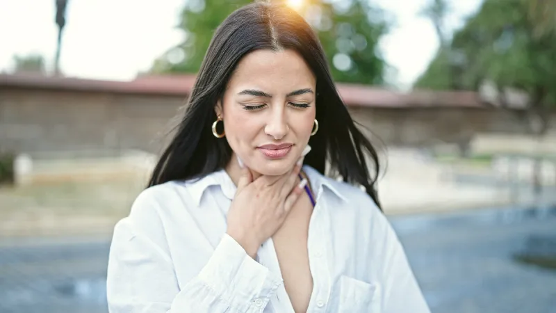 young beautiful hispanic woman being sick standing at street