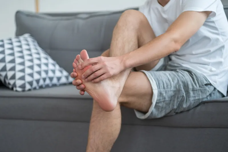 foot pain, man suffering from feet ache at home, podiatry concept