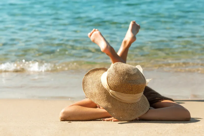 sea holiday on sandy beach sea coast girl in sun hat sunbathing