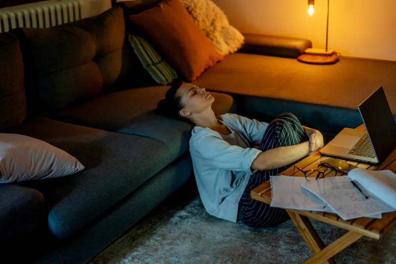 tired depressed young woman working at home at night on a project using a laptop problems with long hours workaholism