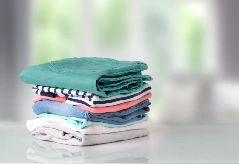 stack of clothes on table indoorhousehold conceptfresh folded cotton clothing