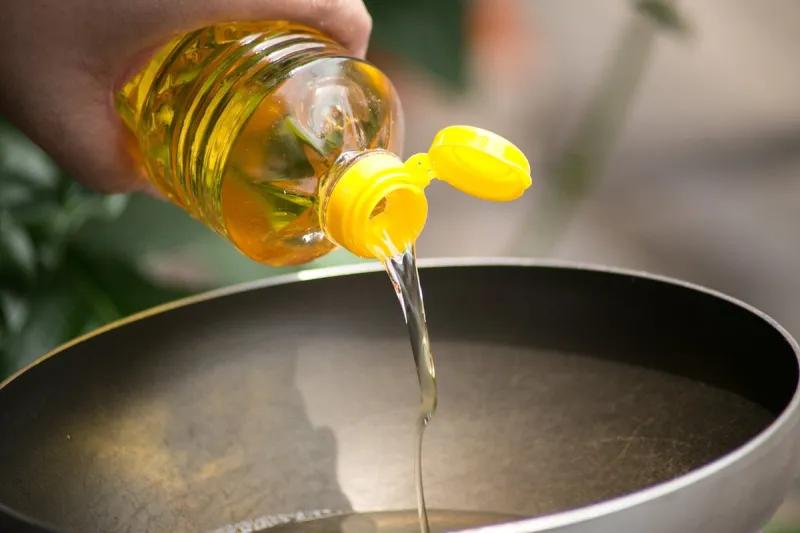 pouring food oil in hot pan for deep frying