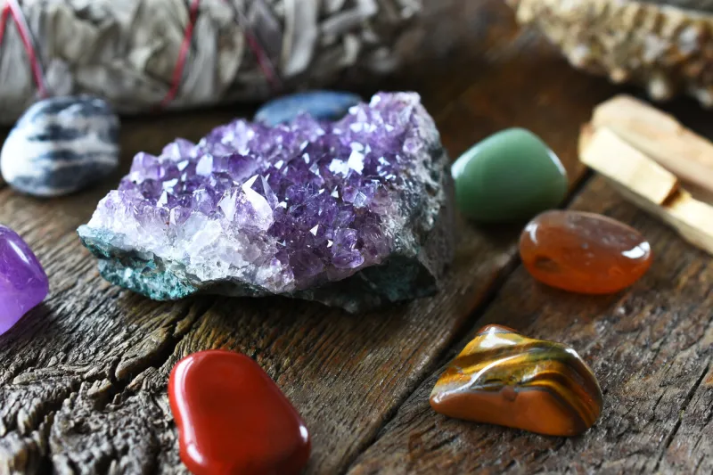 a close up image of chakra crystals surrounding am amethyst geode cluster