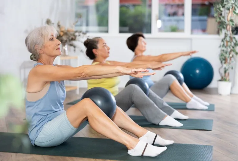 group,of,elderly,women,practicing,pilates,with,soft,ball,in