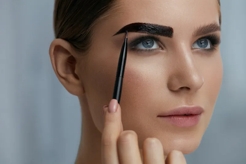 eyebrow coloring woman applying brow tint with makeup brush closeup girl model using liquid peel-off brow gel, beauty product on eyebrows
