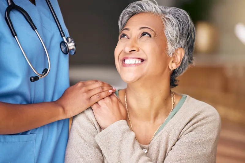 nurse, senior woman and smile with comfort, holding hands or support in nursing home for retirement doctor, medic or caregiver with kindness, empathy or gratitude for help, trust or service in house