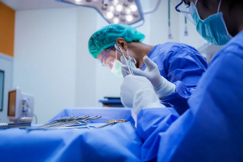 doctor and assistance medical team performing surgery on a patient with focus and stressful moment in operation room in hospital or clinic health concept