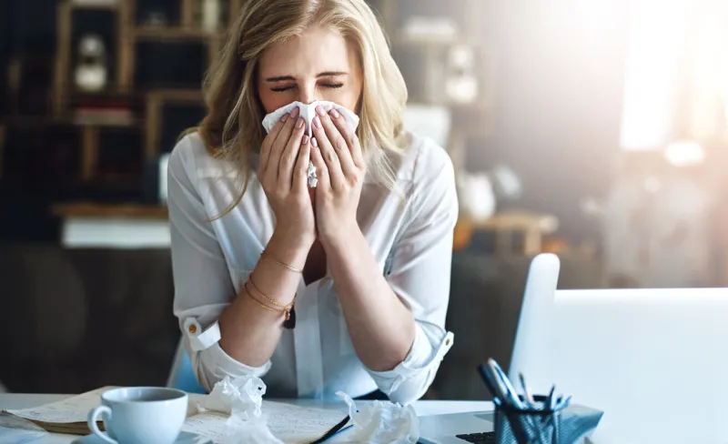 office, blowing nose or sick woman with tissue, flu or allergy with cold, business or illness at desk infection, secretary or female receptionist sneezing with toilet paper, virus or fever disease
