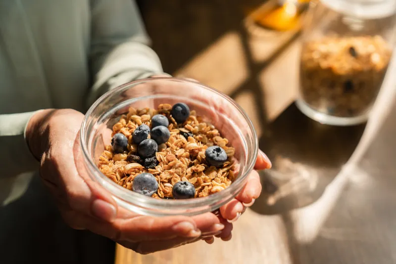cropped closeup shot of bowl full of oat cereals with berries for breakfast healthy eating habits, dietary meal food concept body shaping fitting