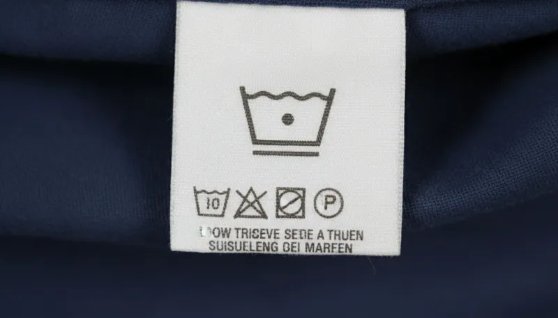 Gros plan sur une étiquette d'entretien de vêtement montrant un symbole de lavage à basse températur