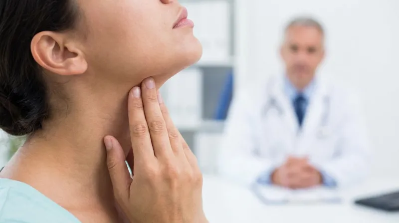 personne qui se palpe un ganglion au niveau du cou