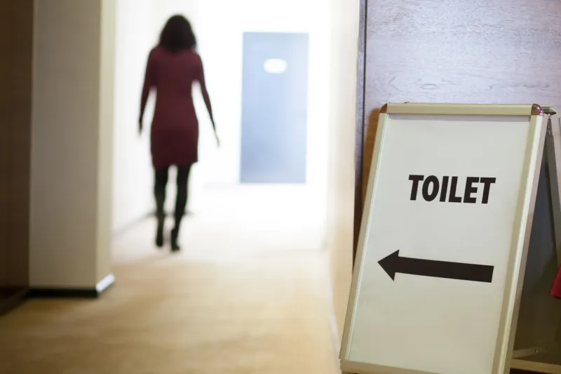 femme qui se rend aux toilettes sans tarder