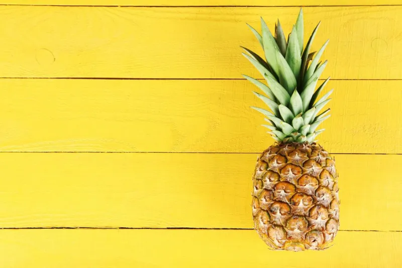 ananas mûrs sur un fond en bois jaune