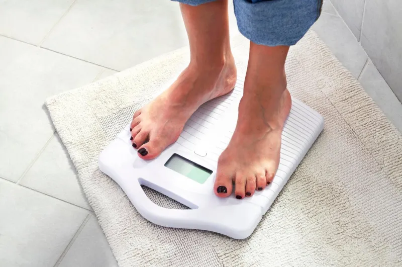 femme contrôlant son poids sur une échelle