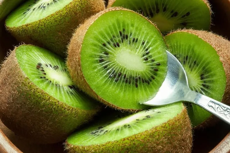 kiwis mûrs juteux dans un bol en bois avec cuillère