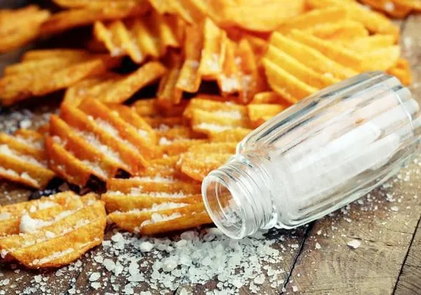 délicieuses croustilles avec du sel sur close-up de table en bois