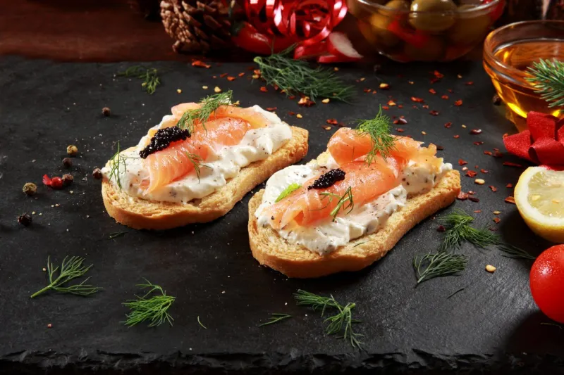 smoked salmon and cream cheese canapes with festive decoration background