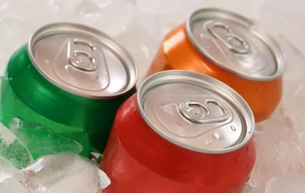 cola froid et limonade en canettes sur des glaçons