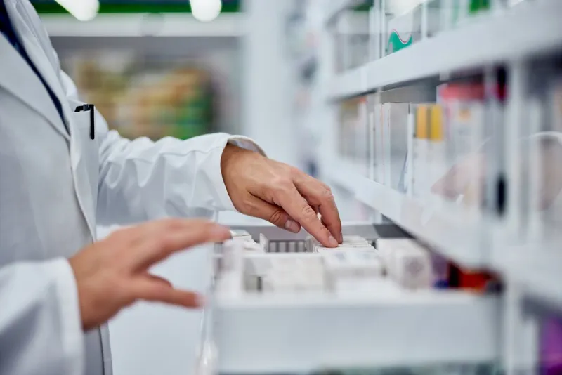 side view of a male hands, searching for something from the drawer, working as a pharmacist