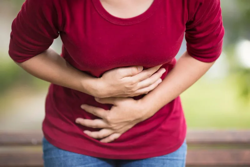 woman has stomach ache at park