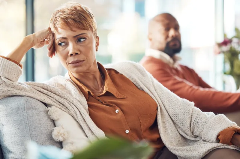 mature couple, divorce and fighting on sofa in house, home living room or marriage counseling therapy stress, frustrated or depression for black woman and man in psychology counselling for cheating