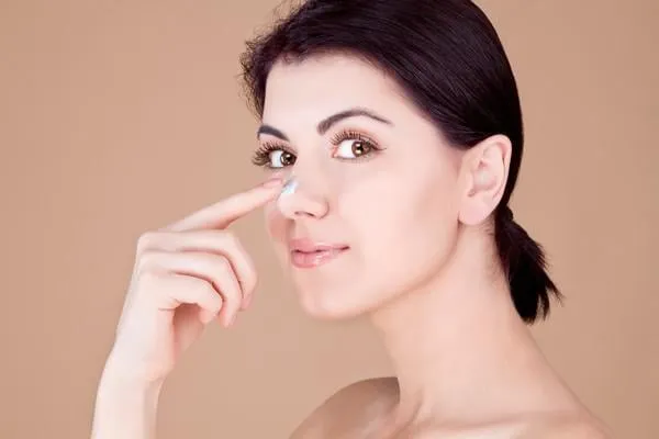 fille touchant son nez avec de la crème (profil)