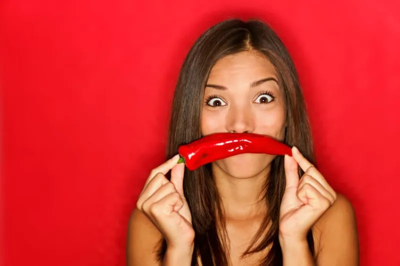 femme chili drôle sur fond rouge tenant des légumes de piment rouge comme la moustache regardant drôle à la caméra belle caucasienne asiatique caucasienne multiculturelle sur fond rouge voir plus