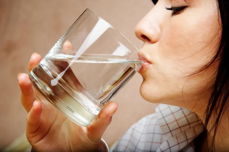 jeune femme avec un verre d'eau minérale