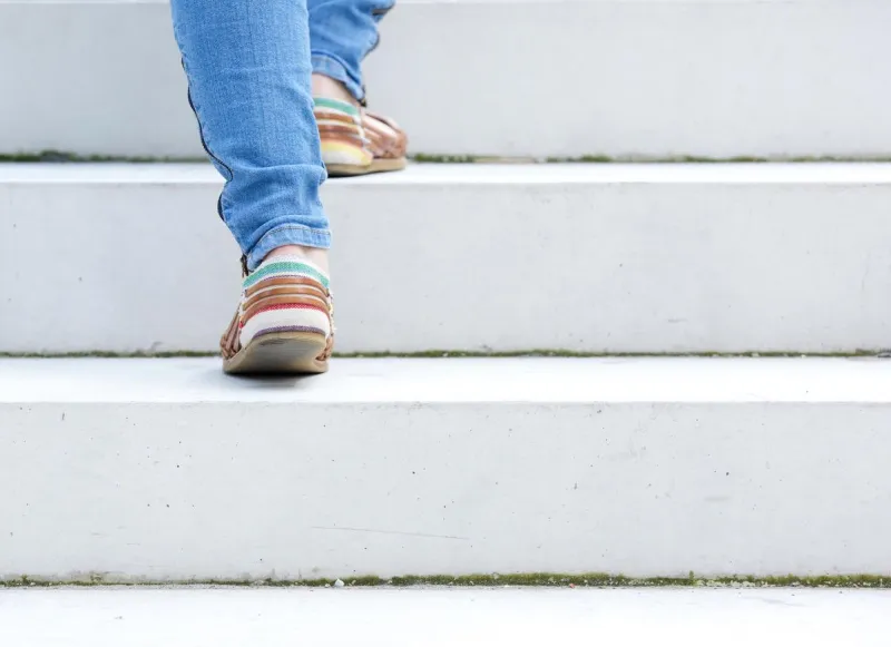 femme marchant à l'étage sur l'escalier de pierre à l'extérieur