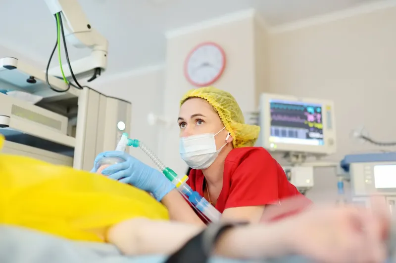 female anesthesiologist injects anesthesia into patient face mask general sedation while surgery operation paramedic putting oxygen mask for breathing and ventilation of person during resuscitation