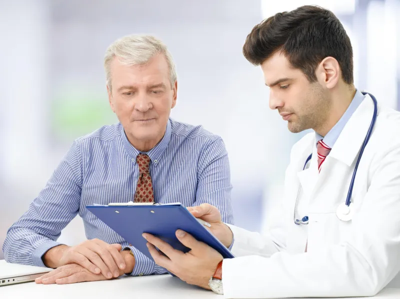 portrait de jeune homme médecin assis au bureau avec un patient âgé et de consultation à l'hôpital