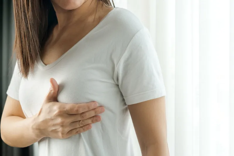 woman hand checking lumps on her breast for signs of breast cancer women healthcare concept