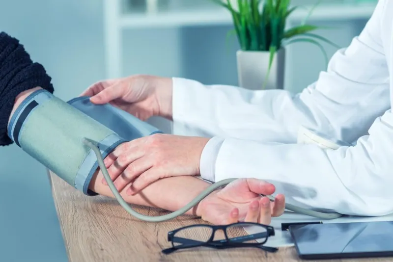 doctor cardiologist measuring blood pressure of female patient in hospital office, health care control and monitoring