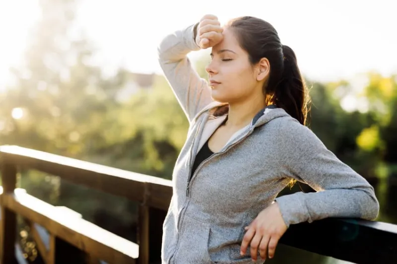 femme fatiguée prenant une pause après avoir fait du jogging dans la nature