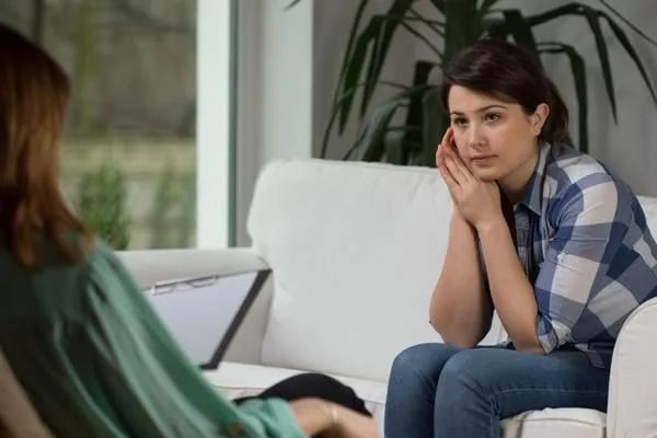 jeune femme parlant avec un psychologue à propos de ses problèmes