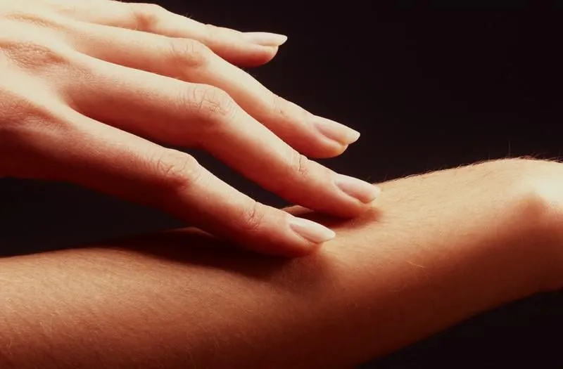 lgère caresse d'un doigt de femme sur son bras