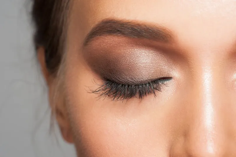 closeup image of closed woman eye with beautiful bright makeup, smoky eyes